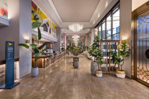 成都Chengdu Taikoo Li Chunxi Mercure Hotel的建筑物大厅里摆放着盆栽