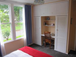 a bedroom with a desk and a bed and a window at Thyme Out Estate in Halcombe