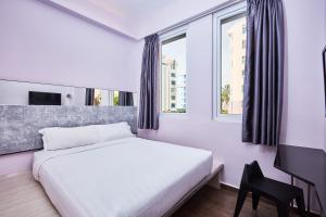 a bedroom with a white bed and a window at ibis budget Singapore Pearl in Singapore