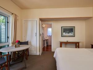 um quarto de hotel com uma cama e uma mesa em Lemon Tree Lodge em Kaikoura