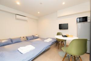 a room with a bed and a table with chairs at Cross Bridge Ikebukuro in Tokyo