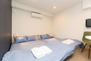 a bedroom with two beds with towels on them at Cross Bridge Ikebukuro in Tokyo +22 photos