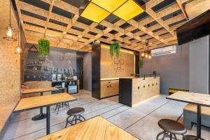 un restaurante con mesas y taburetes de madera en LOBSUEK Hostel หลบศึก โฮสเทล, en Bangkok