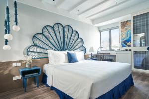a bedroom with a large bed with a blue and white wall at Sofiana My Khe Hotel & Spa- Rooftop Pool Bar in Danang