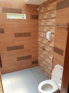La salle de bains est pourvue de toilettes et de murs en bois. dans l'établissement Balenta Bungalow Gili Trawangan, à Gili Trawangan
