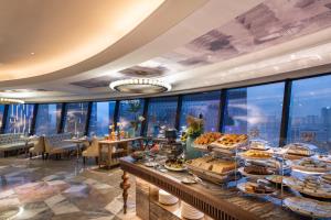 成都Chengdu Taikoo Li Chunxi Mercure Hotel的在可欣赏城市景观的酒店享用自助早餐