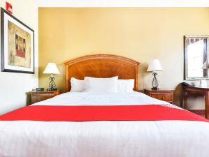 a bedroom with a large bed with a red blanket at OYO Townhouse Oklahoma City Airport in Oklahoma City