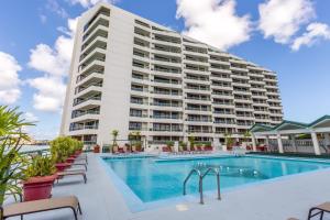 un gran hotel con una piscina y un edificio en Alupang Beach Tower en Tamuning