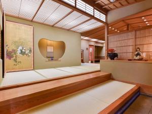 a large room with a large painting on the wall at Yamatoya Besso in Matsuyama