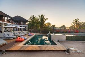 a swimming pool with lounge chairs and a resort at Manduna Resort in Nembrala
