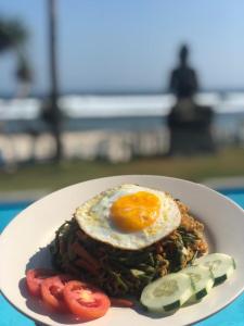 a plate of food with an egg on top at The Tree House Sumbawa in Huu