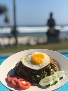 a plate of food with an egg on top at The Tree House Sumbawa in Huu +45 photos