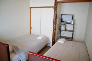 Posteľ alebo postele v izbe v ubytovaní City Pension Tommy Rich Inn Kyoto