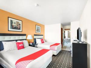 Habitación de hotel con 2 camas y TV de pantalla plana. en Arlington Motor Inn, en Arlington