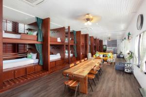 a room with a long wooden table and chairs at Sound Gallery House Phuket Town in Phuket