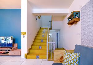 un escalier dans un salon avec un mur bleu dans l'établissement Agastya Villa by VEO - Part of StayVista, à Badami