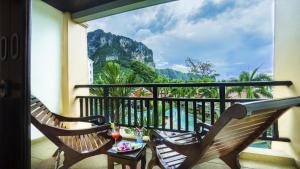 a balcony with two chairs and a view of a mountain at Aonang Orchid Resort - SHA Extra Plus in Ao Nang Beach