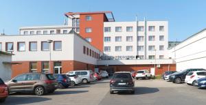 un estacionamiento con autos estacionados frente a un edificio en Hotel Zobor, en Nitra