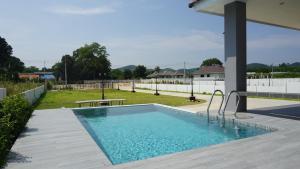 una piscina en el patio trasero de una casa en The Chaleur Pool Villa en Sattahip