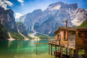 a house on a dock on a lake with a mountain at Hanslerhof in Braies