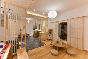 a living room with a table and wooden dividers at Yifangyan - Tingyuan Qingshe Hostel in Fenghuang County