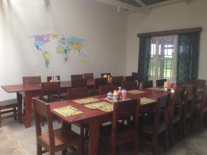 una habitación con mesas y sillas y un mapa mundial en la pared en Bwindi Guest House, en Kinkizi