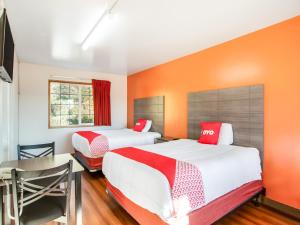 2 camas en una habitación con paredes de color naranja en OYO Hotel Kalama, en Kalama