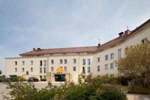 - un grand bâtiment blanc avec un panneau dans l'établissement Première Classe Marne la Vallée - Bussy Saint Georges, à Bussy-Saint-Georges