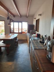 a kitchen with a counter and a table in it at TATAJUBA KITE HOUSE in Tatajuba
