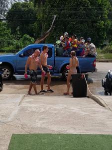 un grupo de personas de pie delante de un camión azul en Best Stay Hostel At Lanta en Ko Lanta