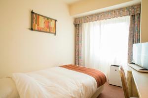 een hotelkamer met een bed en een raam bij ANA Holiday Inn Resort Miyazaki, an IHG Hotel in Miyazaki