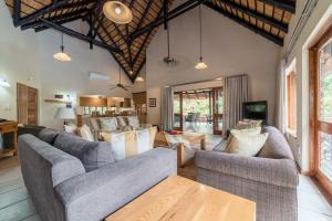 ein Wohnzimmer mit Sofas und einem Tisch in der Unterkunft Kruger Park Lodge Unit No 441 with Private Pool in Hazyview