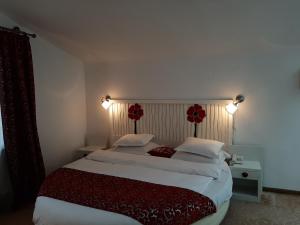 a bedroom with a large bed with two red pillows at Hotel Condor in Oraviţa