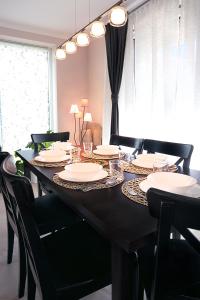 mesa de comedor con sillas negras y platos blancos en Townhouse on Budapest border, en Budaörs