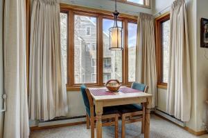 jadalnia ze stołem i kilkoma oknami w obiekcie 2072 The Pines Condo w mieście Keystone