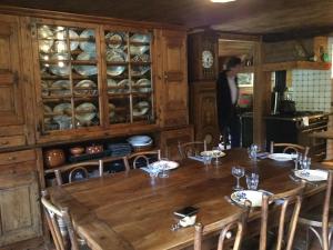 a dining room with a table and a person in a kitchen at Chalet le 1791 in La Clusaz