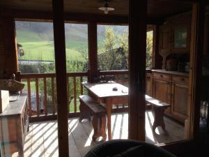 a kitchen with a table and a balcony with a view at Chalet le 1791 in La Clusaz