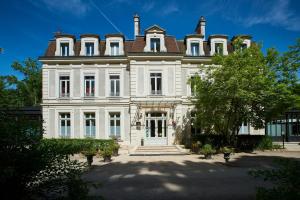a large white house with a roof at Château de La Dame Blanche - Logis in Geneuille