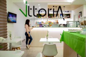 a woman standing at a counter in a restaurant at Vittoria Wellness in San Giuseppe Vesuviano