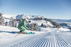 a person is skiing down a snow covered slope at Appartement Angelika in Brixen im Thale