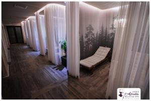 a corridor with white curtains and a chair in a room at Bacolux Afrodita Resort & SPA, Herculane in Băile Herculane