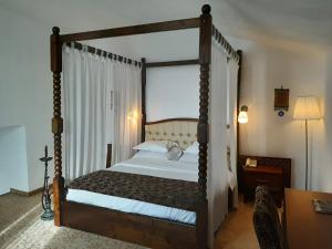 a bedroom with a four poster bed with a canopy at Hotel Condor in Oraviţa