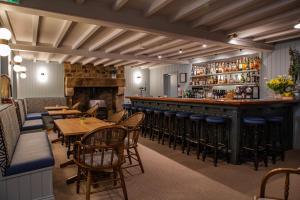 a restaurant with tables and chairs and a bar at Beausite Hotel in Grouville