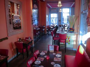 ein Restaurant mit roten Stühlen und Tischen und einer Bar in der Unterkunft Hotel Oldenburg in Zwolle