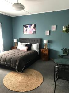 1 dormitorio con cama y pared azul en Admirals Lodge, en Picton