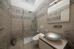 La salle de bains est pourvue d'un lavabo et d'une douche en verre. dans l'établissement Hotel L'Ariana ISOLE EOLIE - UNA Esperienze, à Leni