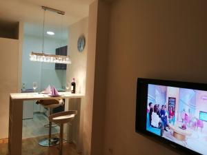 a living room with a tv and a bar at Apartman Lux in Nova Pazova