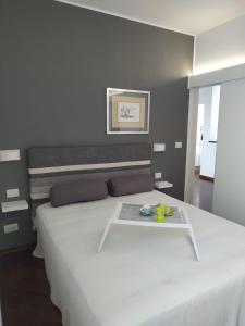 a bedroom with a large white bed with a tray on it at Michi's Home - Attico in Centro in Bari