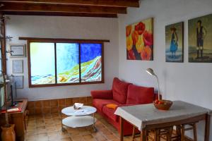 sala de estar con sofá rojo y mesa en Casa Rural Tile, en Roque