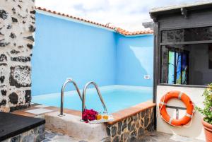 Casa azul con patio con piscina en Casa Rural Tile, en Roque